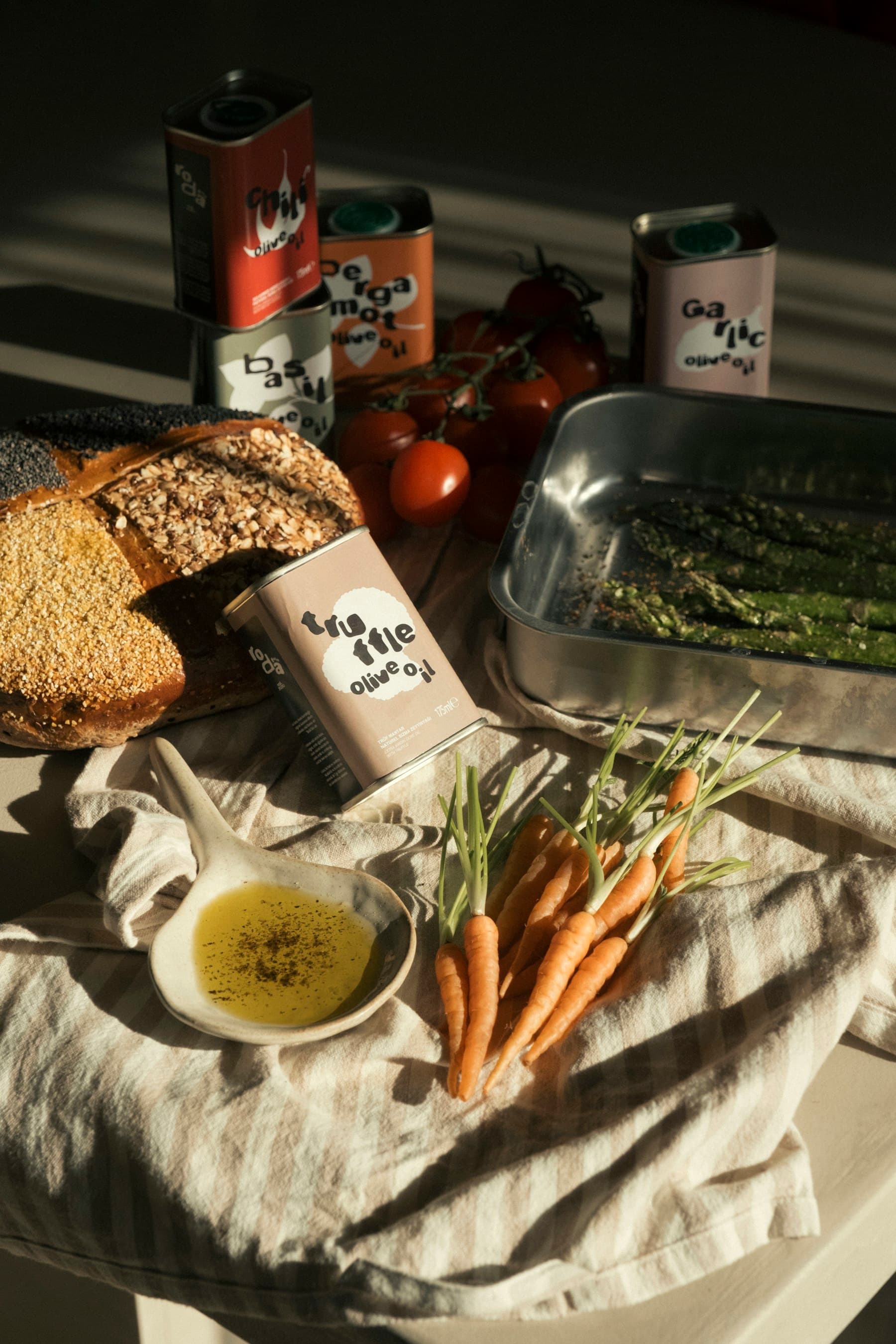 Pan, aceite, tomates y verduras sobre una mesa mientras se prepara una comida